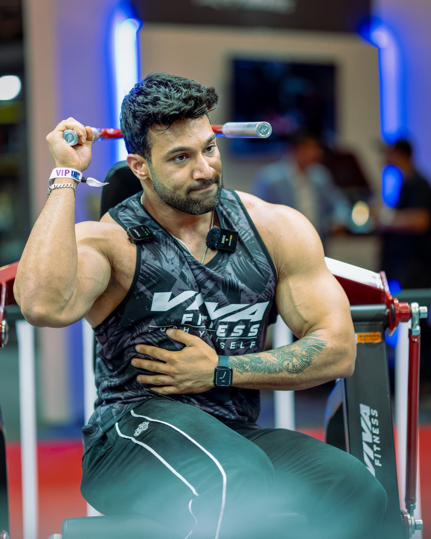 Bearded bodybuilder seated at a lat pulldown machine gripping the bar