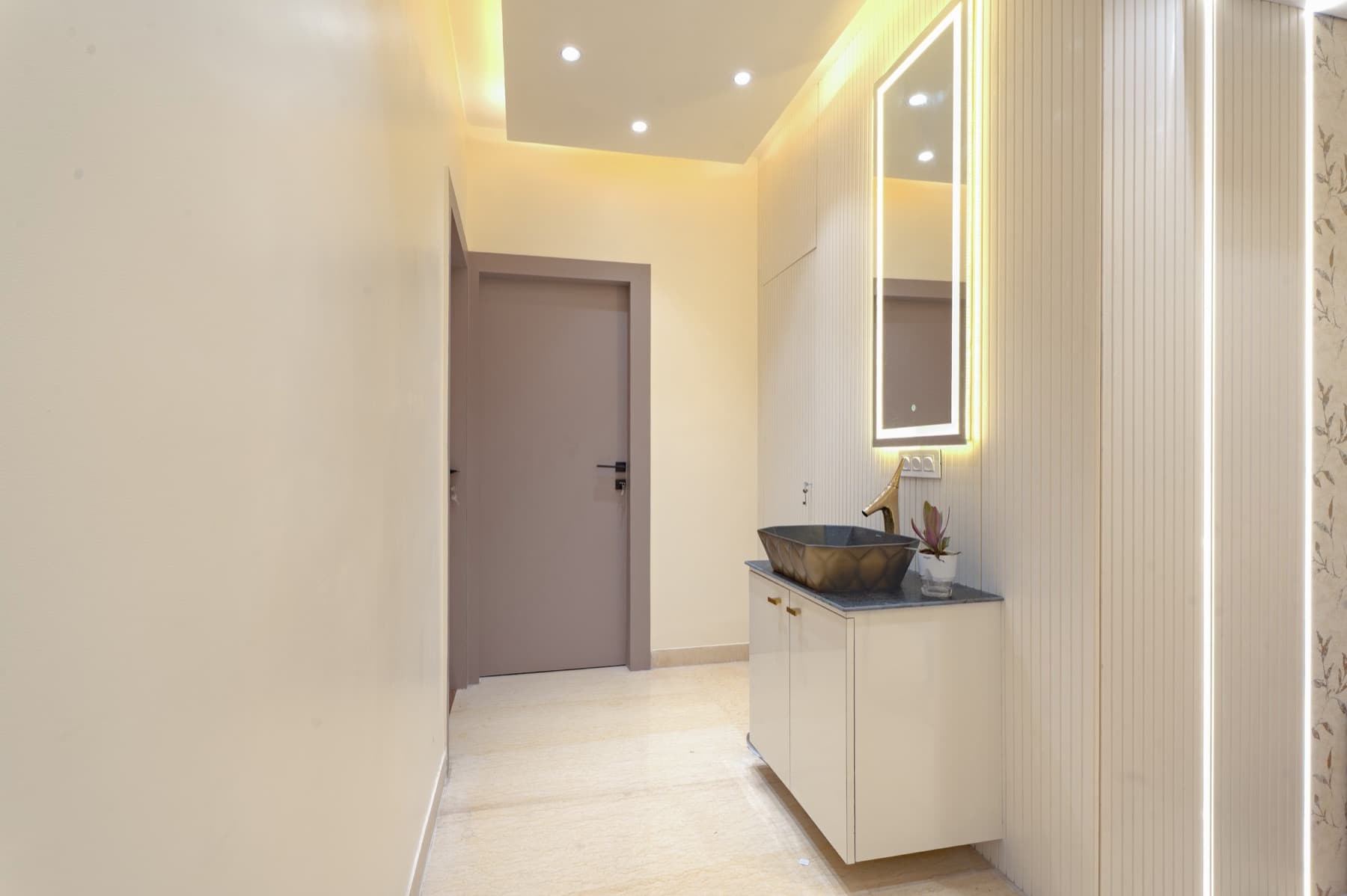 Hallway vanity with stone vessel basin, gold tap and backlit full-length mirror